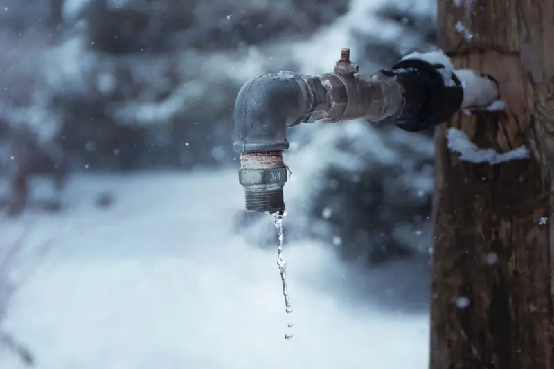 Frozen outdoor faucet dripping in the snow, the kind of hard freeze that bursts pipes in Cary, NC homes