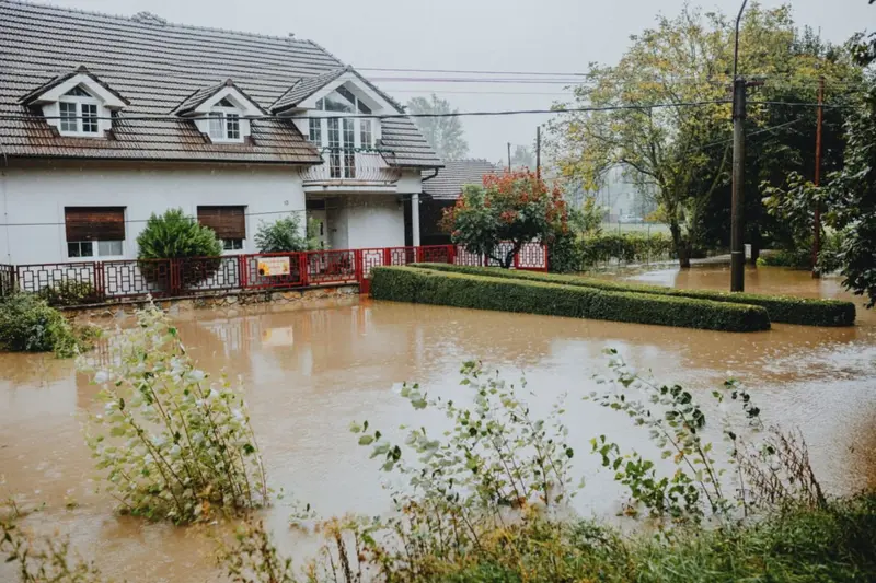 House surrounded by brown floodwater after heavy rain, the kind of storm flooding cleaned up in Cary, NC