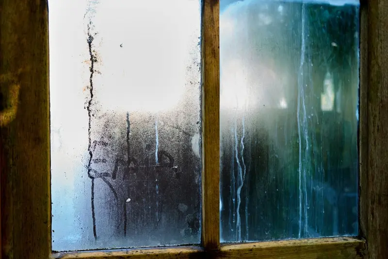 Condensation running down the inside of a wooden window, a sign of high indoor humidity in Cary, NC homes
