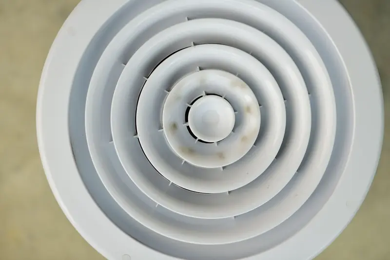 Round ceiling air diffuser with dark discoloration around it, a common sign of mold near AC vents in Cary, NC