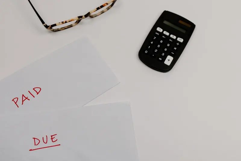 Bills marked paid and due beside a calculator, the kind of budgeting a mold remediation quote in Cary, NC calls for