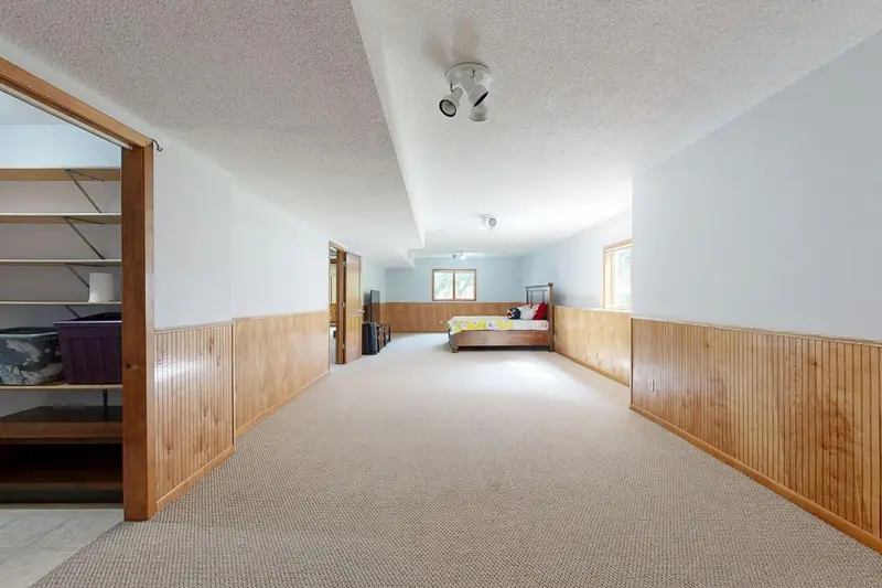Finished lower-level hallway with carpet and wood paneling, the kind of space where a musty smell lingers in Cary, NC homes