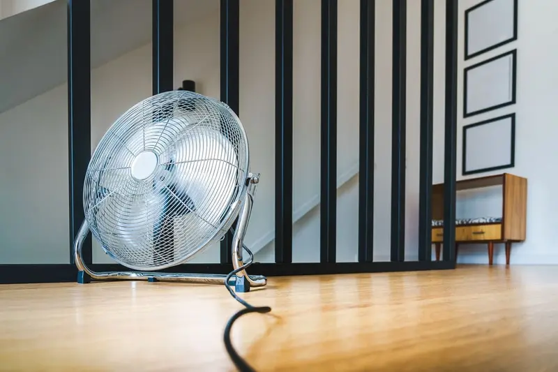 Floor fan on a hardwood floor, like the air movers used for structural drying in Cary, NC homes