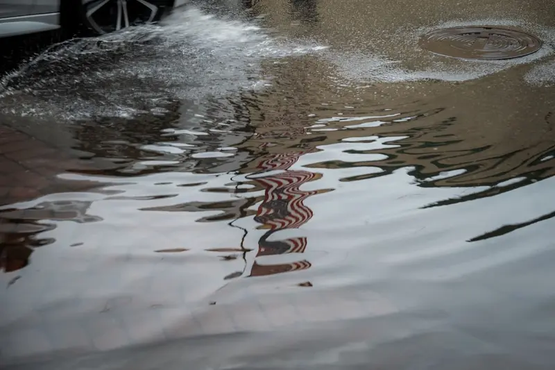 Murky floodwater rippling across a flooded street, the Category 3 black water that requires full cleanup in Cary, NC